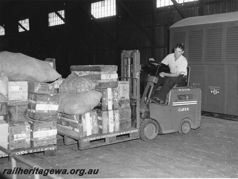P00277
VF class bogie van, being loaded by a forklift, view of the forklift on the platform picking up a loaded pallet.
