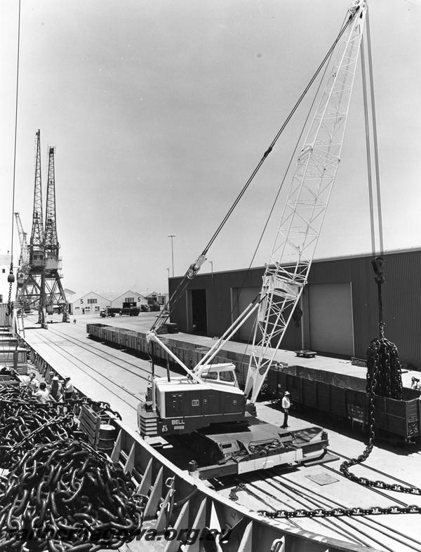 P00296
RCA class wagons being loaded with chain from a ship at Fremantle Harbour by a crane owned by 