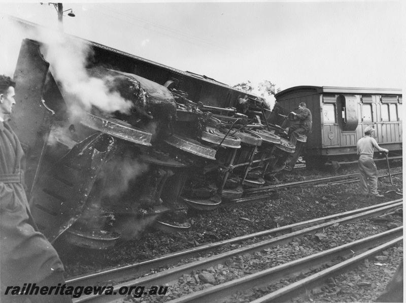 P00446
4 of 4 views of DM class 585 on No. 195 Passenger  derailed and lying on its side, Midland Junction, view of the underside of the loco, end of AD class 46 in the view. Date of derailment 30/7/1953
