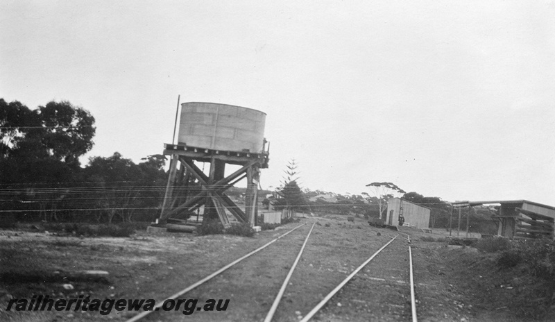 P01422
1 of 4 images of the buildings and other structures at the Ravensthorpe station precinct, HR line, water tower with a circular tank, station building, carpenter's shed, goods shed and wheat stacking areas on top of the cutting
