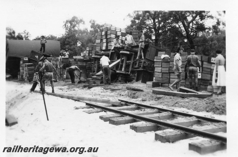 P02026
2 of 4 views of a derailment of No. 22 Fast Goods at the157-78 mile point on the Donnybrook to Katanning Railway, DK line, between Noggerup and Goonac, bogie van derailed, fruit case stacked beside the track, , date of derailment 26/3/1955
