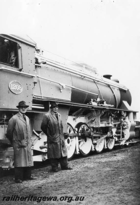 P02339
V class 1208, in works grey and black livery, taken in the yard of Robert Stephenson and Hawthorne, Springfield, Darlington, England, two men in front of the loco, one being Harry Scrafton, view from the cab forward, accompanying letter in the envelope.
