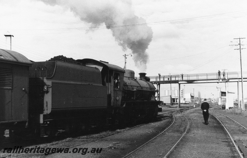 P02525
W class 920 steam locomotive, side view, footbridge, Ampol fuel tanks, signal box, lever frame, signals, Bunbury, SWR line. c1970.
