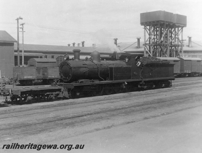 P02688
O class 225 steam locomotive shunting in the yard at Bunbury, front and side view, water tower with a 25,000 cast iron water tank in the background, SWR line.
