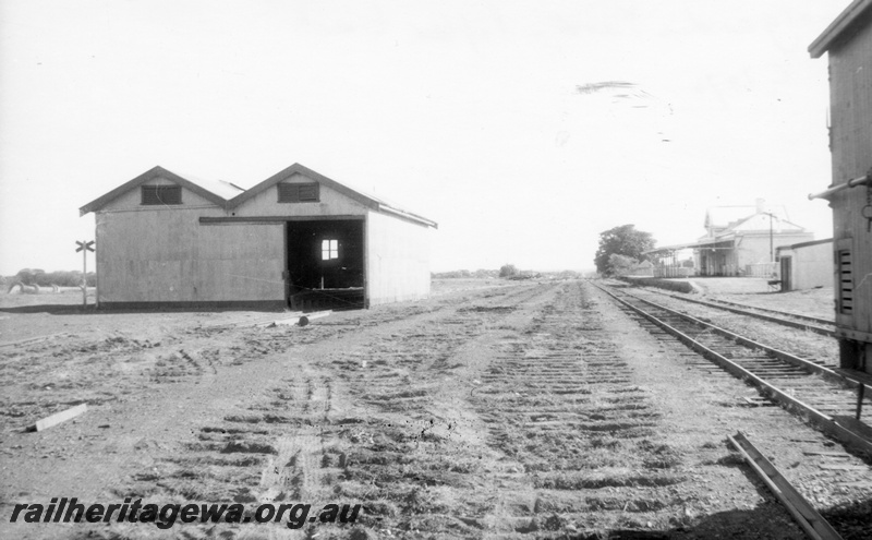 P02927
Track bed showing sleeper indentations after track being lifted, end view of the goods shed, station building, passenger platform, Coolgardie, EGR line, c1970.
