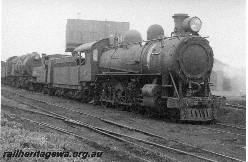 P03003
L class 237 steam locomotive stabled with two other steam locomotives, side and front view, water tower with a 25,000 gallon cast iron tank, railway workshops, Midland. 
