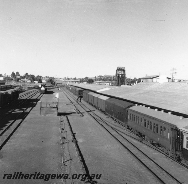 P03263
East end of Kalgoorlie station, passenger train at platform, water tower, lever frame between the tracks in the station yard, EGR line.
