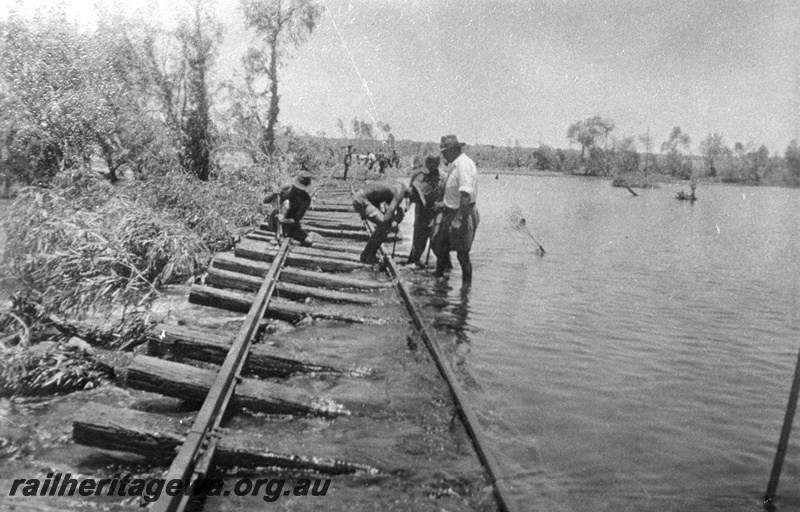 P03380
Washaway on the PM line, the Shaw river in flood, view along the track with workers 
