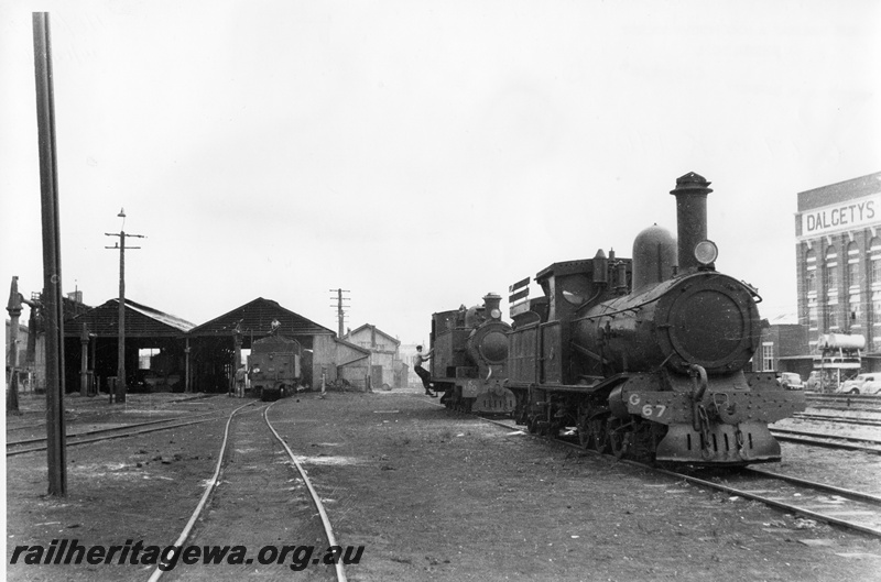 P03695
G class 67, K class 190, loco shed, part Dalgetys wool store, Fremantle, ER line, side and front view

