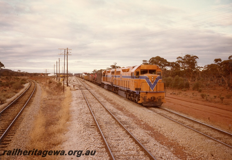 P03908
4 of 4, L class 266 diesel locomotive leading a triple headed freight train, running short hood first, side and end view, Westrail orange livery, on route to Forrestfield.
