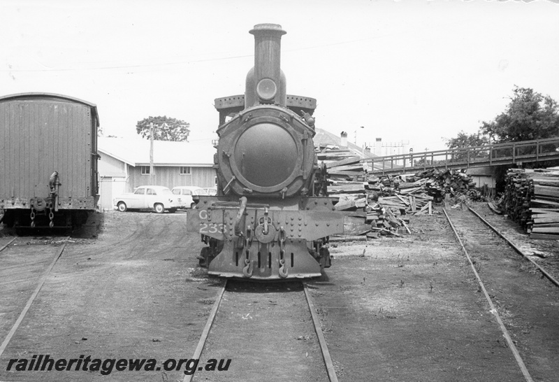 P04360
G class 233 steam locomotive, front view, wood pile, foot bridge.
