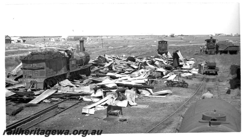 P07715
1 of 8 views of the burnt down running shed at Port Hedland, PM line on 9.10.1950, the night before the annual visit by the Chief Boiler inspector (Jack Farr), accompanied by a fitter (Ted Bosworth) and a boiler maker. G class 234 was badly damaged in the fire. G class 234 amid the ruins of the shed with H class 22 and G class32 behind the debris
