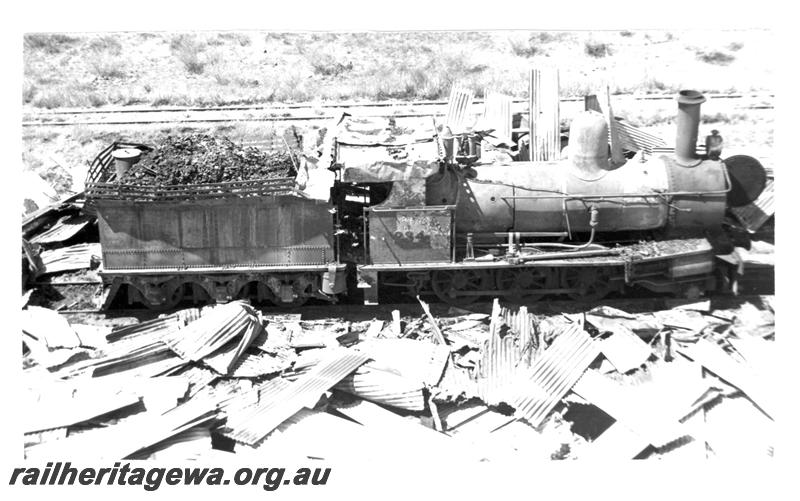 P07717
3 of 8 views of the burnt down running shed at Port Hedland, PM line on 9.10.1950, the night before the annual visit by the Chief Boiler inspector (Jack Farr), accompanied by a fitter (Ted Bosworth) and a boiler maker. G class 234 was badly damaged in the fire, side view of fire damaged G class 234
