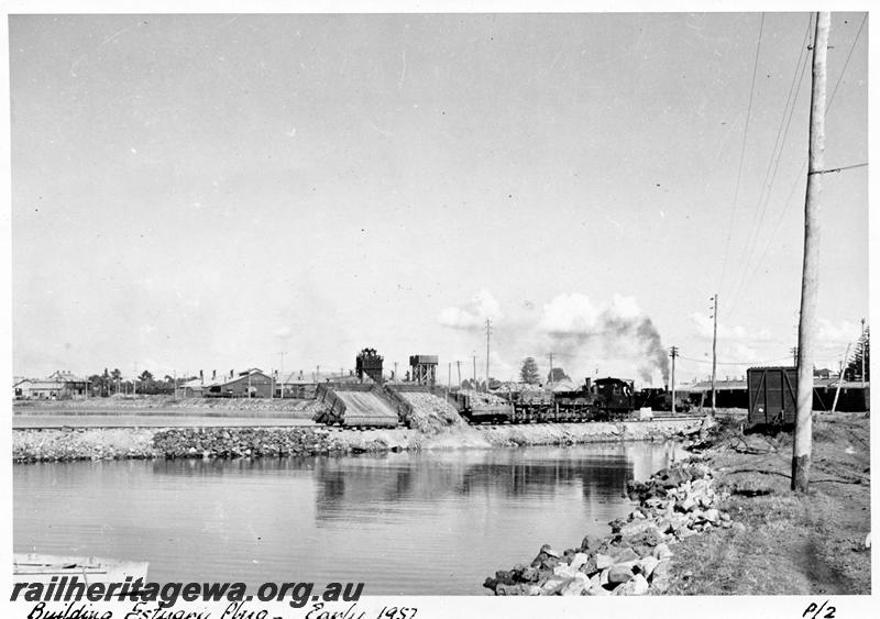 P08387
H class 18, side tipping wagons, Bunbury Estuary Plug, dumping rock into water, roundhouse in the background
