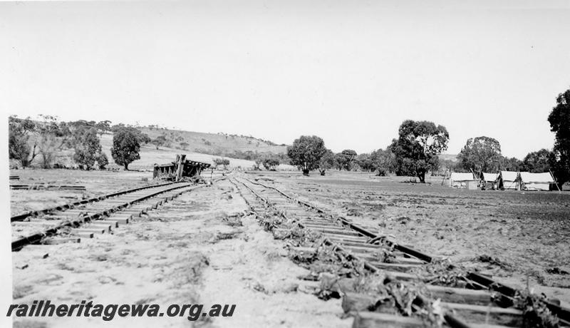 P08874
10 of 15 views of the aftermath of the washaway at Coondle, CM line on the 3rd of March 1934, view of the damaged track at the location of siding with gangers tents in view.
