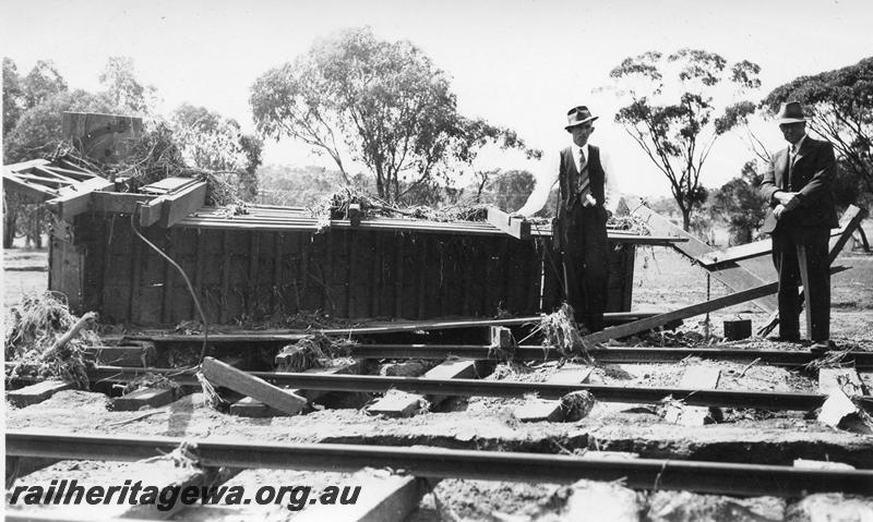 P08875
11 of 15 views of the aftermath of the washaway at Coondle, CM line on the 3rd of March 1934, view shows suited gentlemen next to an unidentified structure displaced by the flood
