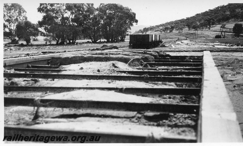 P08877
13 of 15 views of the aftermath of the washaway at Coondle, CM line on the 3rd of March 1934, view of the deck of the loading platform with structure exposed due to the surface material being washed away.
