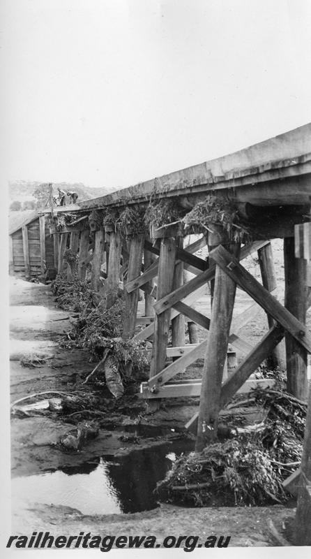P08878
14 of 15 views of the aftermath of the washaway at Coondle, CM line on the 3rd of March 1934, view of a trestle bridge with flood debris caught up on the trestle bents up to deck level
