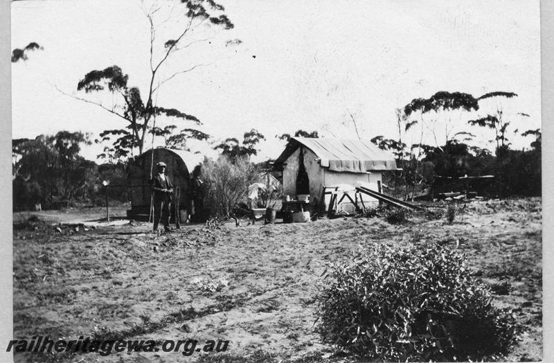 P08896
12 of 29 views of the construction of the Wyalkatchem-Lake Brown-Southern Cross railway, WLB line. Worker standing outside his tent.
