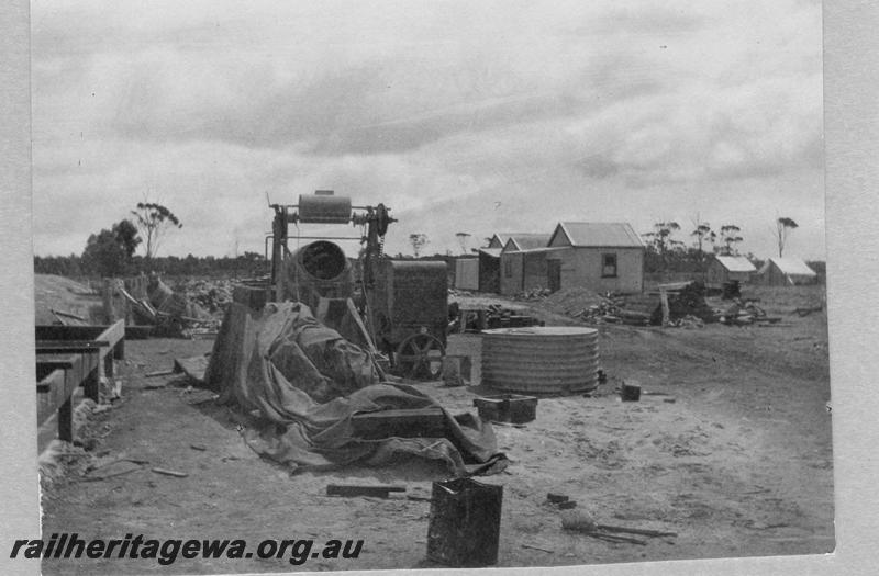 P08906
22 of 29 views of the construction of the Wyalkatchem-Lake Brown-Southern Cross railway, WLB line. Worksite with a cement mixer in the foreground and cabins in the background
