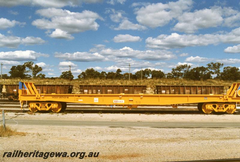 P08921
1 of 5 views of WQEF class 30743-M, standard gauge flat wagon with end bulkheads, side view. This wagon is a former WVX class then WBAX class van cut down to carry sodium cyanide tank containers.
