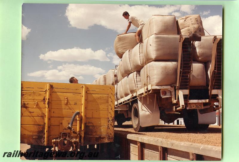 P08981
GE class 4 wheel wagon being loaded with wool bales from a semi trailer truck, end view of the wagon
