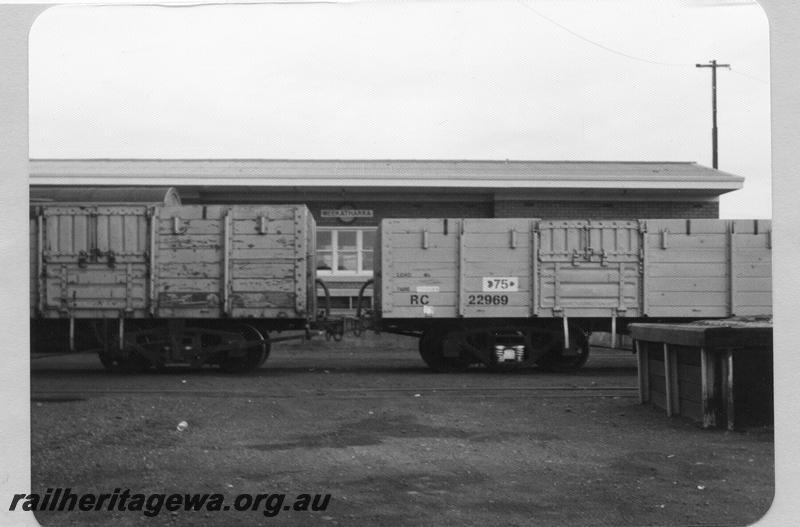 P09510
Meekatharra yard, wagons in front of station building, nameboard, end of loading bank at right. NR line.
