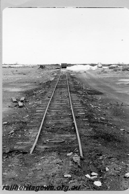 P09512
Meekatharra, end of WAGR, start of Peak Hill tramway, northernmost point on WAGR at that time, view along the line, wagons being loaded from trackside pile of material. NR line.
