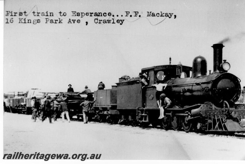P09585
G class hauling the first train to Esperance, location Unknown, square wooden water tank wagon coupled behind the loco
