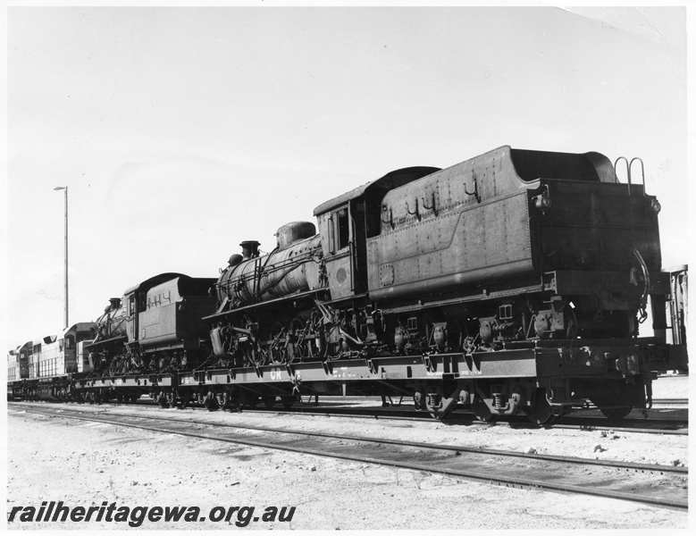 P10433
W class 934 and W class 933 steam locomotives loaded on Commonwealth Railways (CR) flat top wagons for re-locating to Pitchi Ritchi Railway Preservation Society in South Australia, side and end view, Forrestfield.
