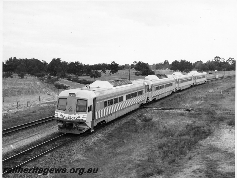 P10455
Prospector 4 car railcar set within the Forrestfield - Kwinana section of railway. Note the left leading door of the railcar is open and steps have been set down.
