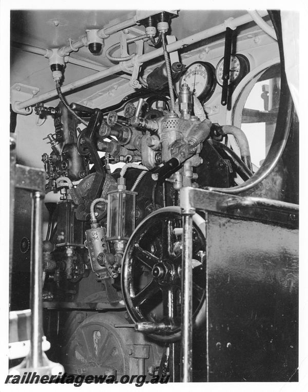 P10509
G class steam locomotive cab depicting reversing wheel, vacuum brake handle, steam regulator, boiler pressure gauge and vacuum brake gauge.
