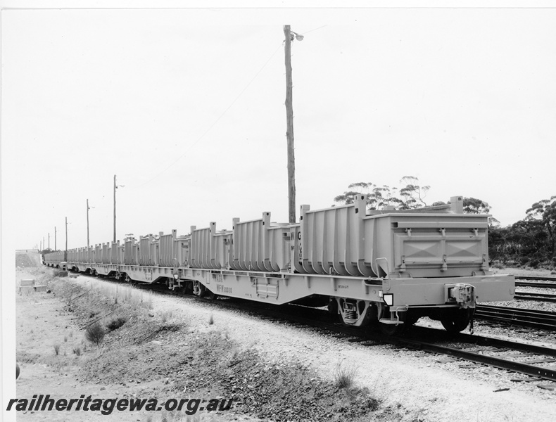 P10522
WFW class 30030 flat top wagon loaded with empty iron ore containers at the loading ramp at Koolyanobbing. The ore was destined for Wundowie. End and side view of container and wagon.
