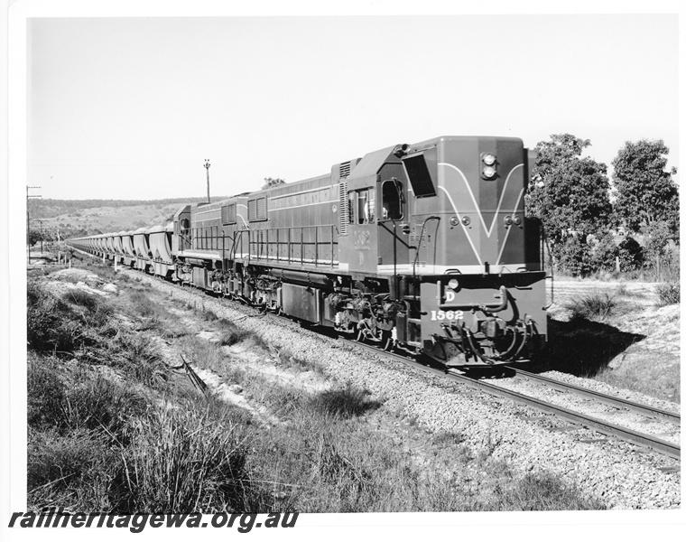 P10526
D class 1562 diesel locomotive with a similar locomotive at the head of a loaded bauxite train enroute to Kwinana. Front and side view of leading locomotive.
