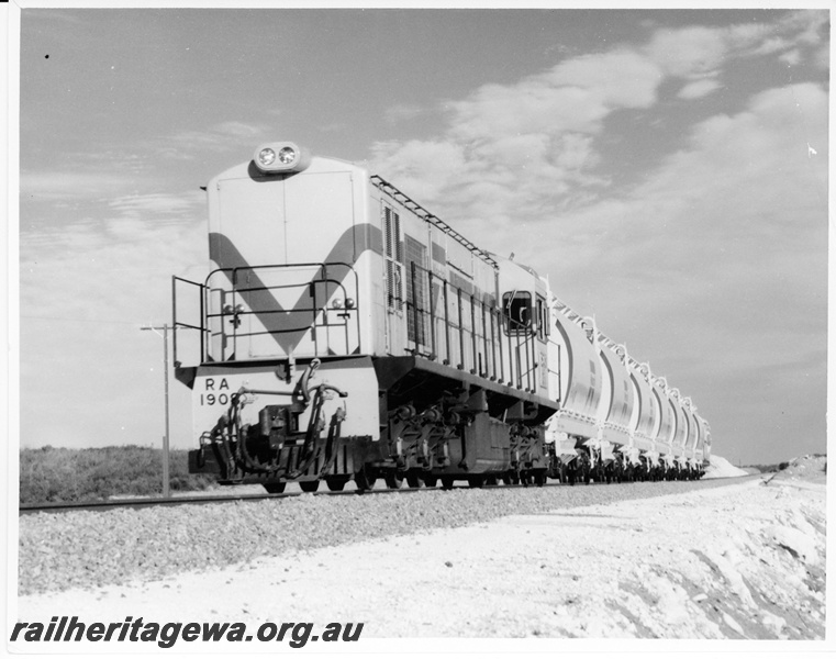 P10538
RA Class 1908 diesel locomotive, Westrail orange with blue and white stripe, with a short rake of XE Class ilmenite hopper wagons between Dongara and Eneabba. Front and side view of locomotive.

