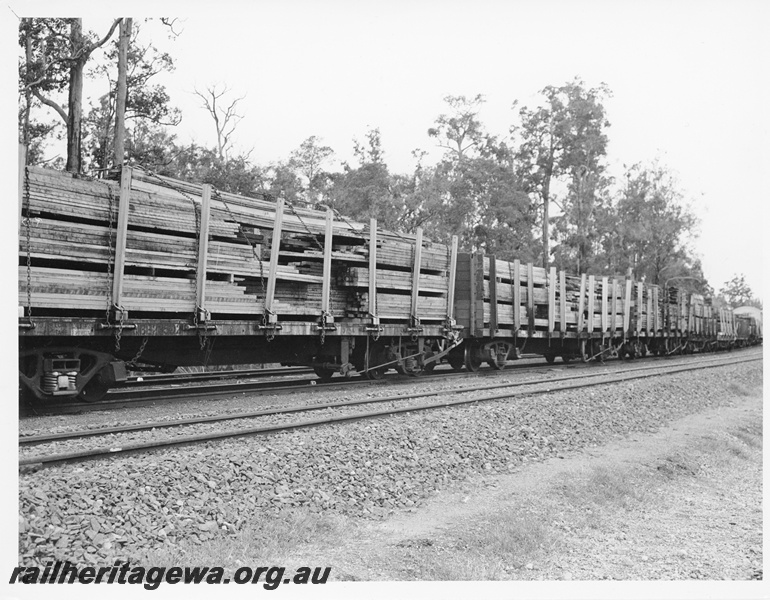 P10576
A rake of flat top wagons, with stanchions fitted, loaded with sawn timber as part of the load of a goods train in the South West of the State.
