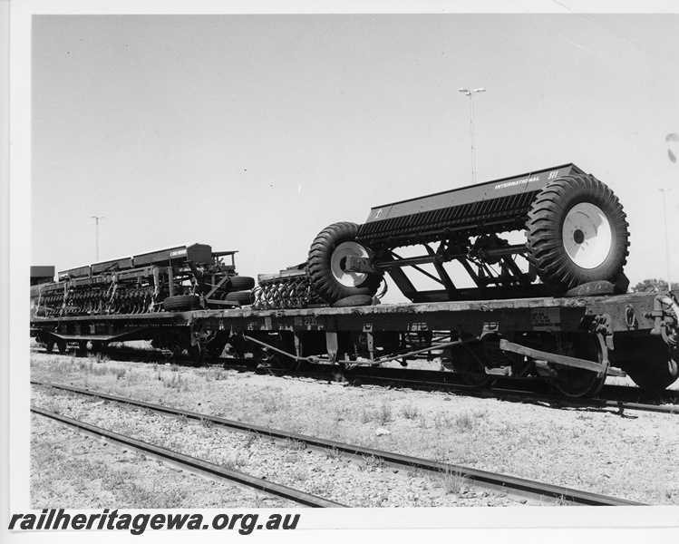 P10603
QRB class 2735 flat top wagon loaded with an 'International' seeder unit. Adjoining wagon, QU class flat top, loaded with farm machinery.
