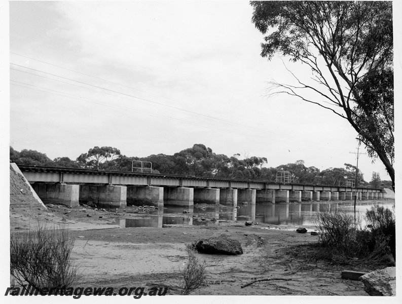 P10656
Concrete and steel rail bridge over river, resting on 22 piers, rural setting, view from one bank
