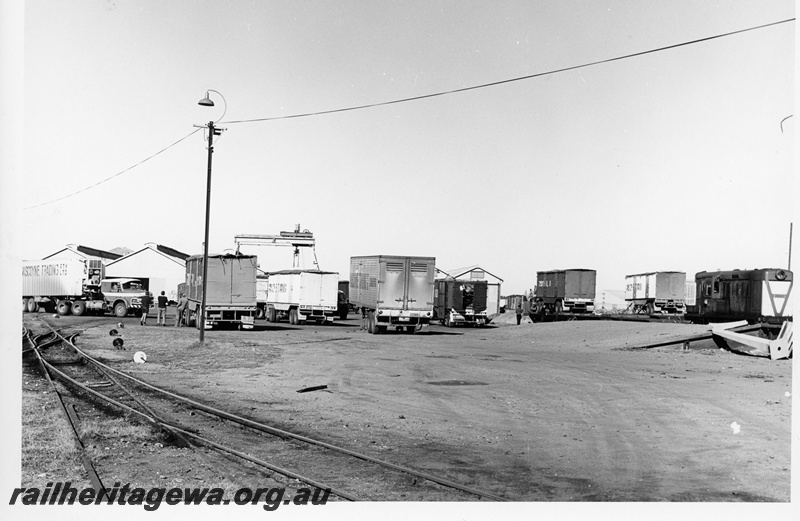 P10667
Y class diesel with inverted A on white end, piggy back siding and truck park, various road trailers and trucks, double slip, loading ramp, Geraldton
