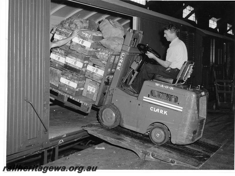 P10681
Clark WAGR forklift, driver, loading WAGR No 19 pallet of boxed vegetables into van, hand trolley, old Perth Goods depot, side view
