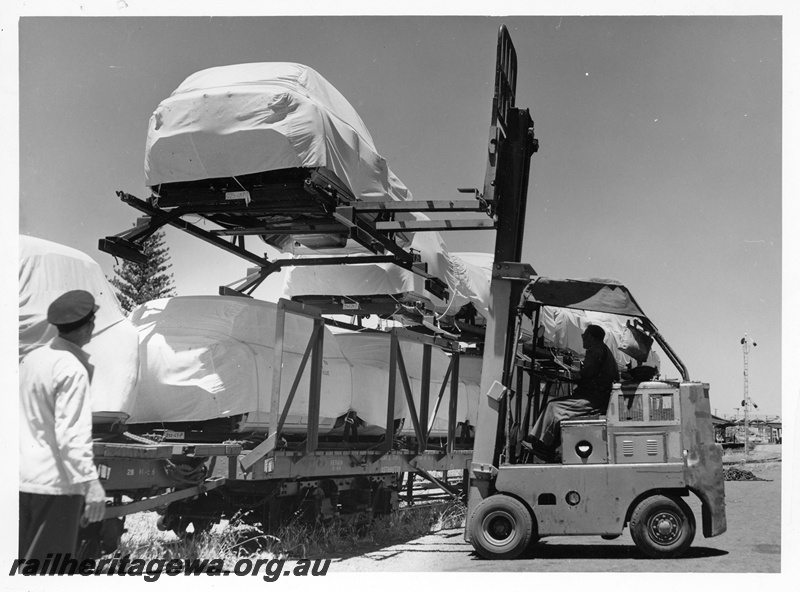 P10759
A forklift unloading motor car bodies from a QMB class narrow gauge car carrier at Cottesloe. Note the semaphore signal in the background.

