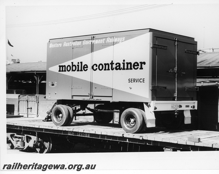 P10775
QCE class 23588 narrow gauge flat top wagon loaded with a road trailer set up as a mobile container service carrying parcels and other non perishable traffic.
