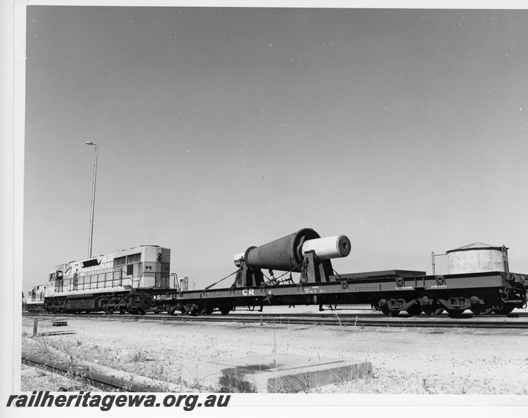 P10860
L class 271, on Commonwealth Railways flat bed wagon GB class 2407, loaded with the interior shaft of a crusher from the Mount Newman mine. The shaft was carried by rail from Perth to Newcastle for machining due to wear. Side and end view
