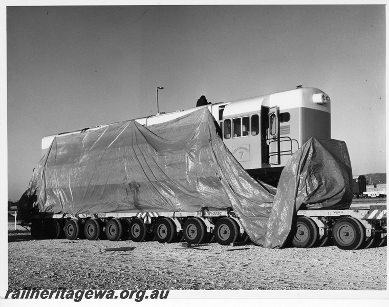 P10895
Goldsworthy Mining(GML) A class 7 at Forrestfield being prepared for the road trip to Port Hedland. The photo shows the locomotive wrapped in plastic for the road journey. 
