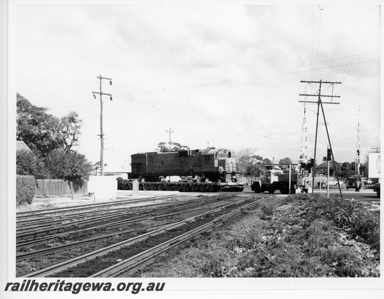 P10899
Mount Newman (MNM) C636 class 5458 on road transporter crossing the WAGR railway lines at Great Eastern Hwy level crossing East Guildford . Locomotive enroute to Tomlinson Steel Welshpool for rebuilding.
