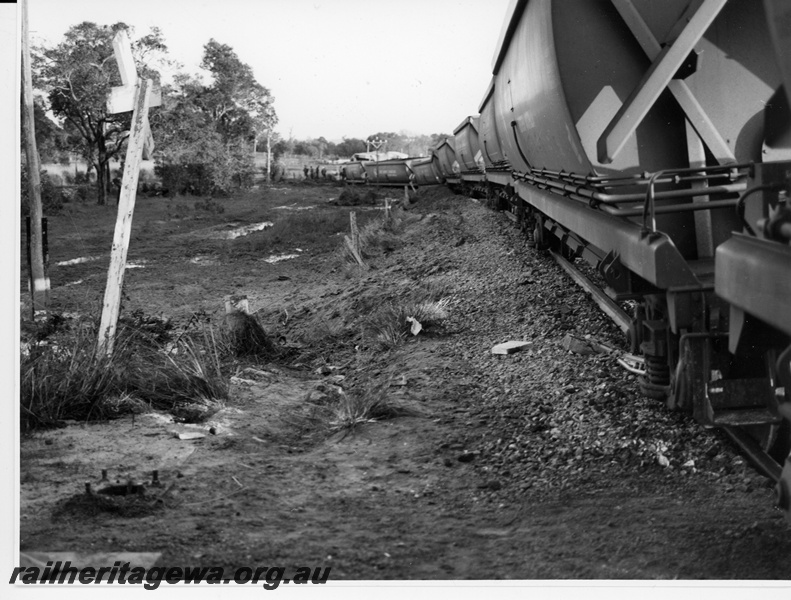 P10951
4 of 7. View from mid train towards front depicting the derailed XG class coal hoppers at Wagerup, SWR Line. The road crossing sign is seen to the left.. Date of derailment 11/9/1981
