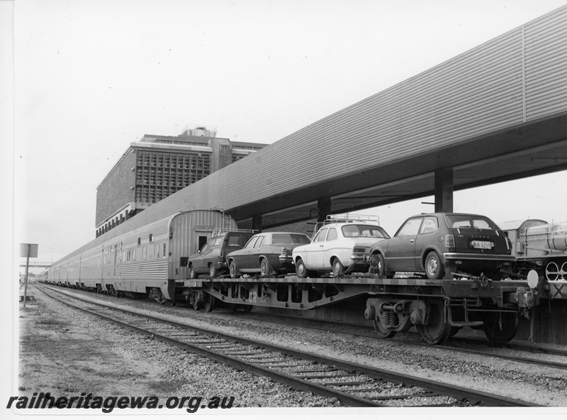 P10958
Perth Terminal depicting a Commonwealth Railways (CR) RM class flat top wagon loaded with passenger's motor cars. The wagon will be detached from the train to enable the motor vehicles to be unloaded. Portion of S class 542 'Bakewell