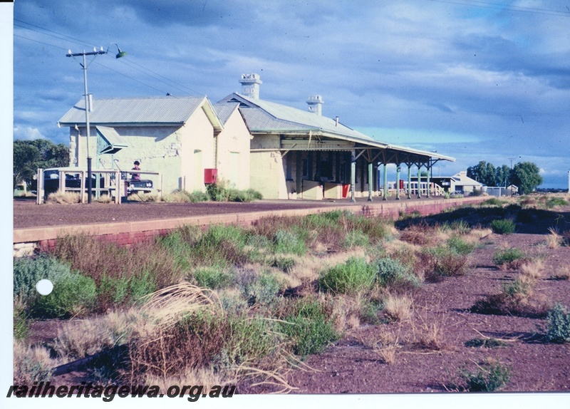 P10961
Mount Magnet railway station, pictured c1980s. What remains of the track is overgrown by weeds. The signal frame was still intact at the time of the photo.
