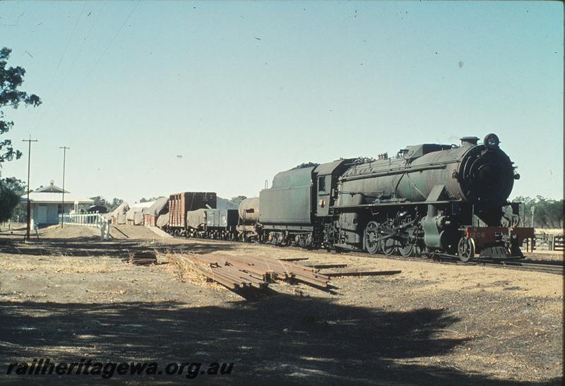 P11291
V class 1206 with auxiliary water tank and ex MRWA AC class wagon on goods train, station building, platform, Popanyinning, GSR line.

