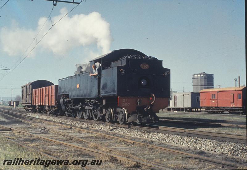 P11562
DD class 597 with a short goods train consisting of an RCB class bogie open wagon and a green Z class brakevan, wires for SEC electric loco, arriving East Perth. SWR line. The DD class loco does not have bifurcated spokes on the driving wheels.
